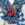 Détail bijou rouge coquillage sur robe blanc-bleu