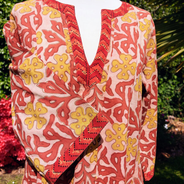 Détail encolure rouge sur robe Naina motifs indien jaunes et rouges