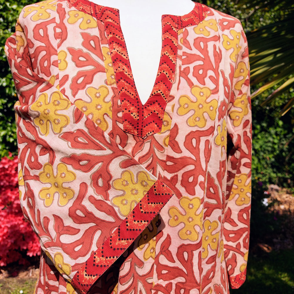 Détail encolure rouge sur robe Naina motifs indien jaunes et rouges