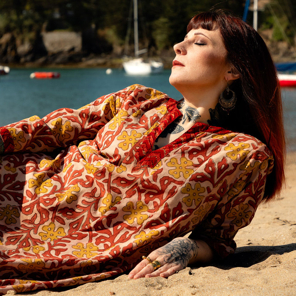 Robe Naina indienne portée sur une plage allongée
